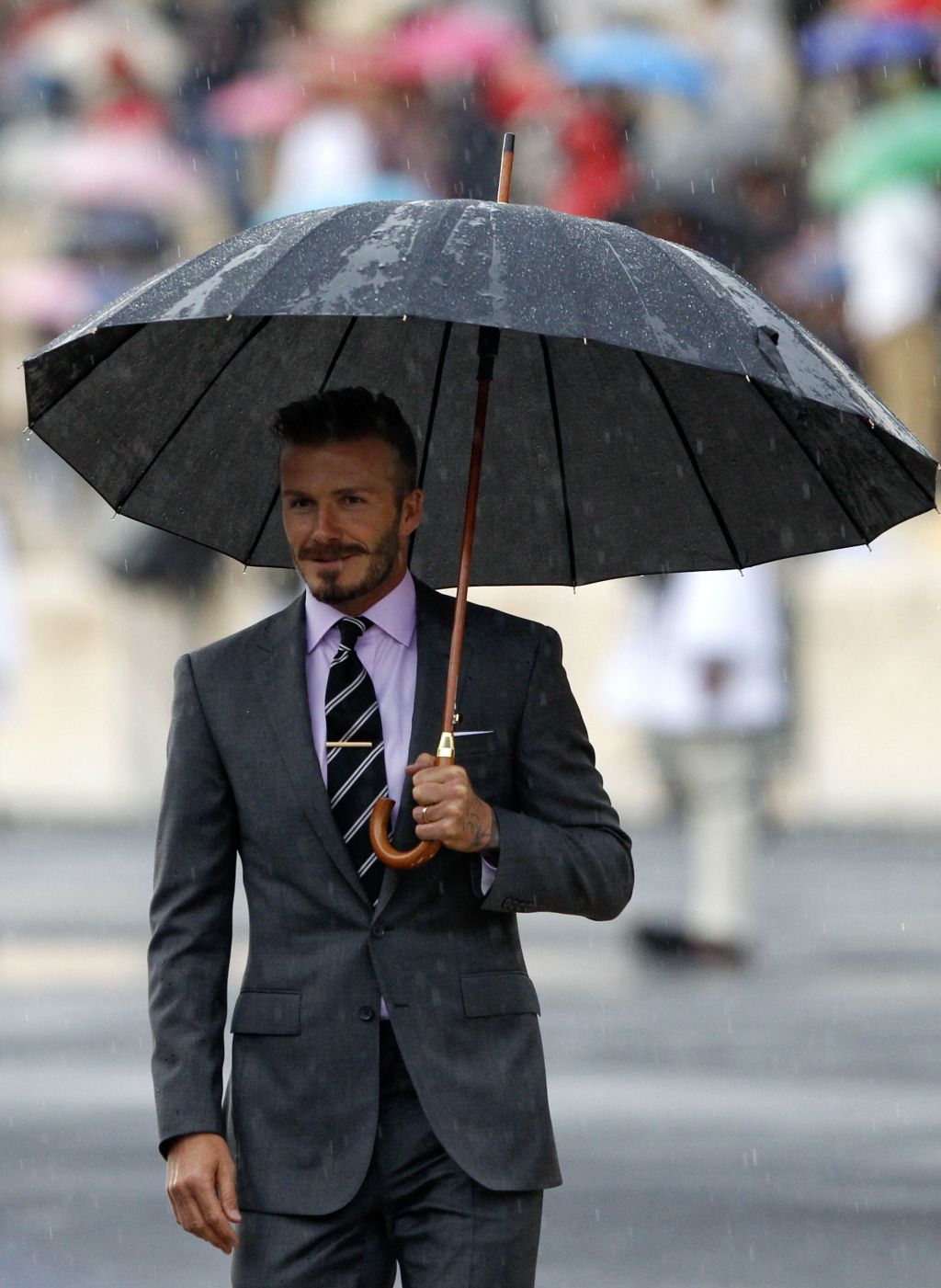 David Beckham v dežju prejel olimpijski ogenj