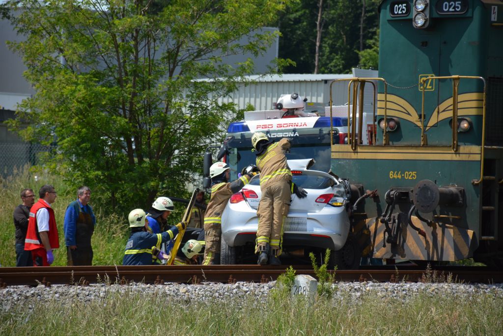 FOTO: Po trku z vlakom avto uničen, voznika odpeljali
