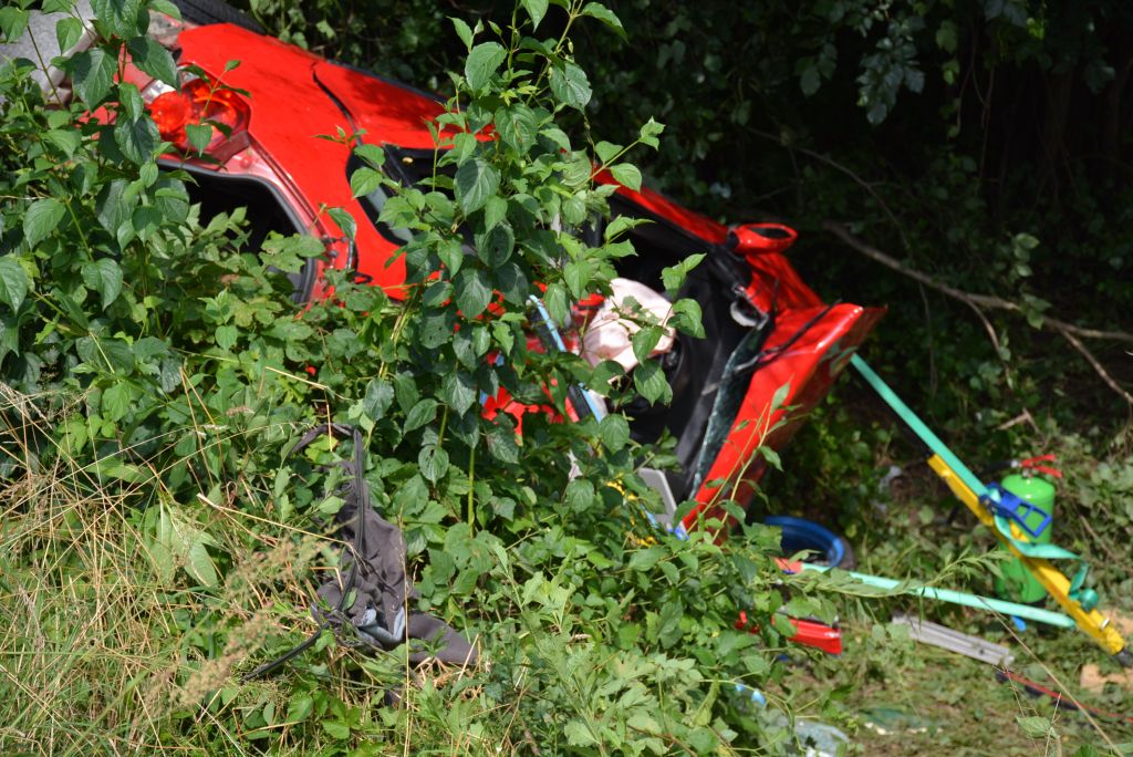 FOTO: Voznik preletel ograjo, iz razbitin so ga reševali